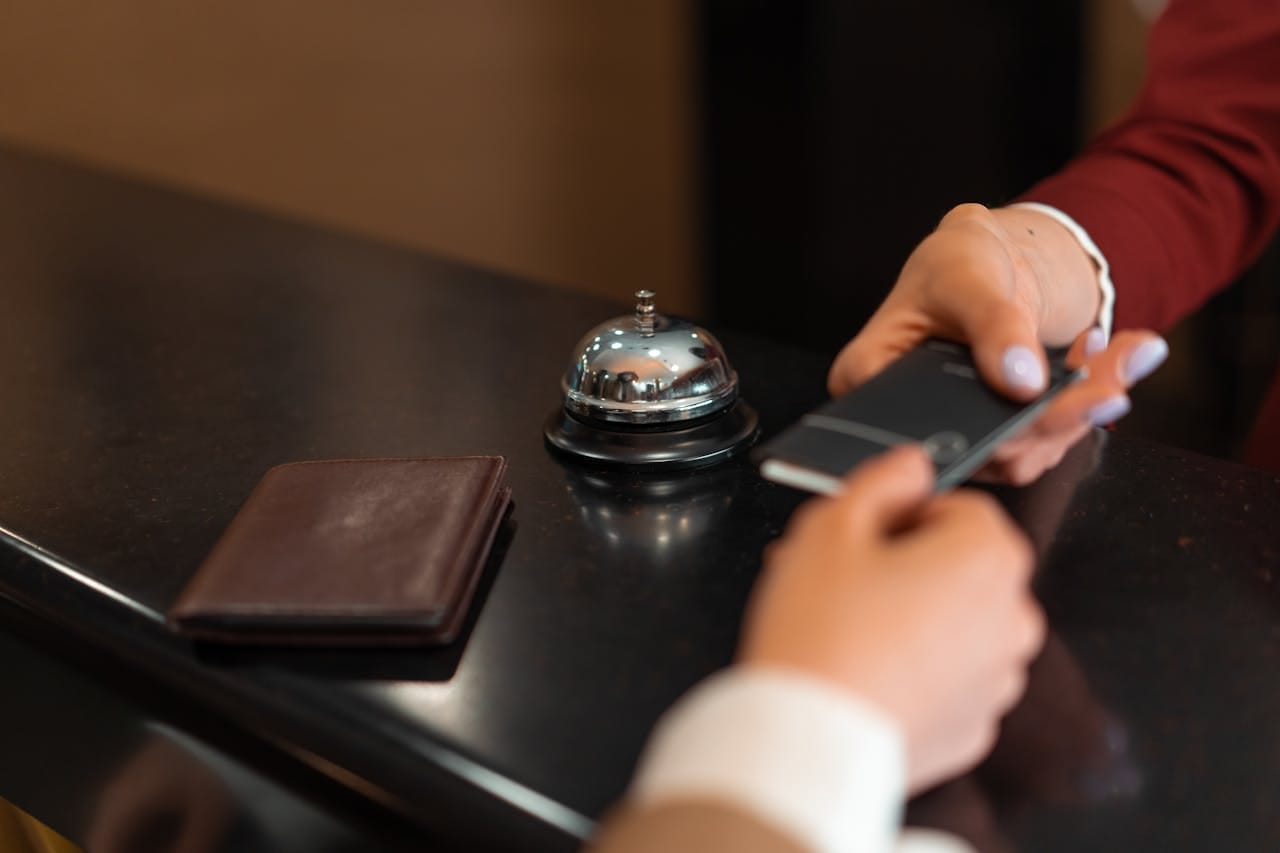 A person holds out a payment card for a guest.