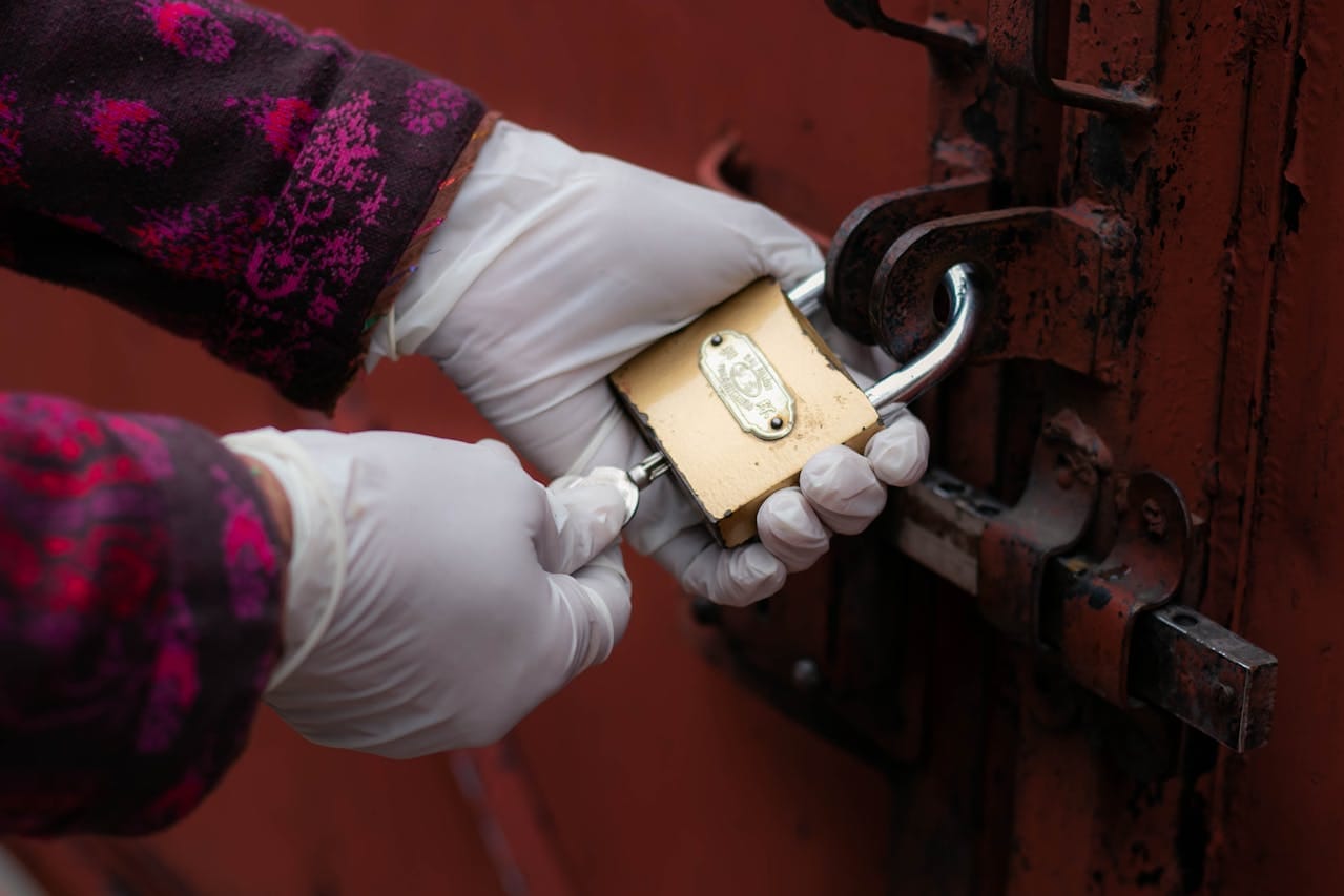 A person holds a gold padlock