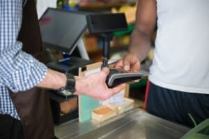 A man swipes a card at a register.