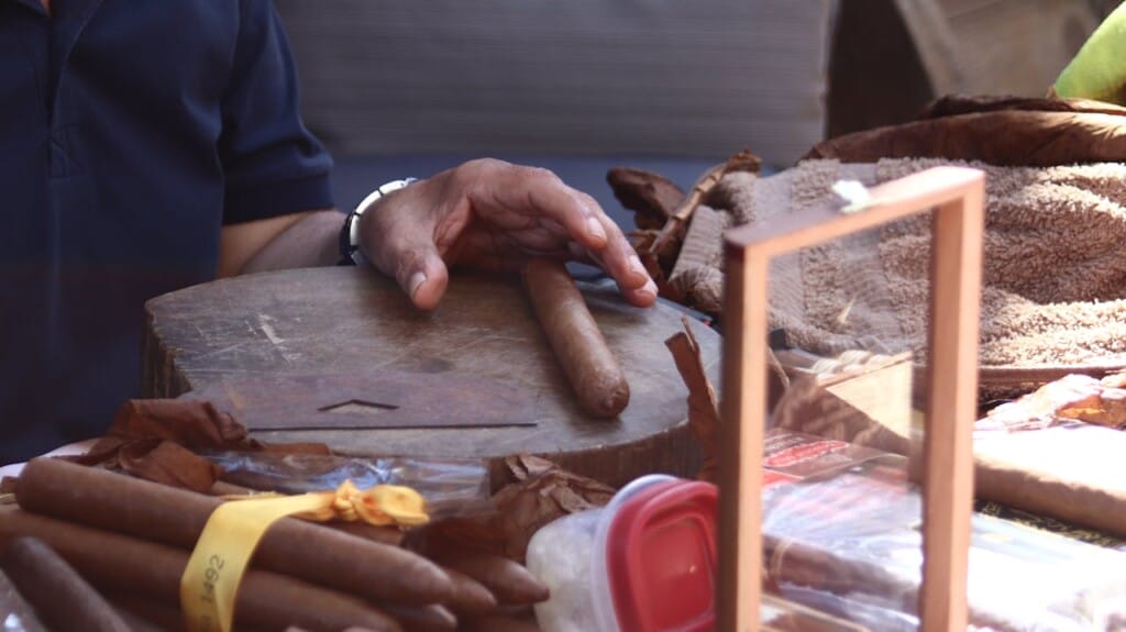 A person picking up a cigar.