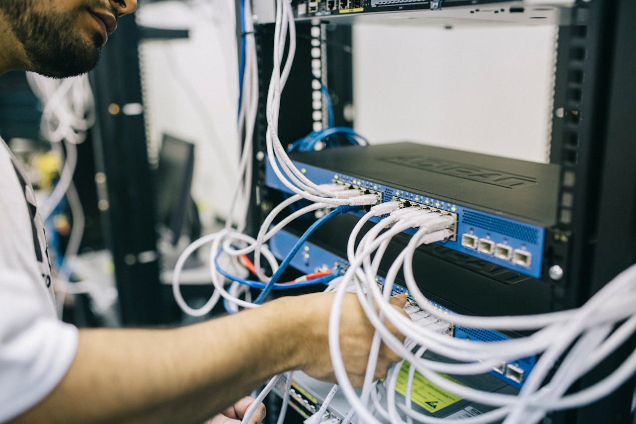 Technician troubleshooting network equipment in a server rack.